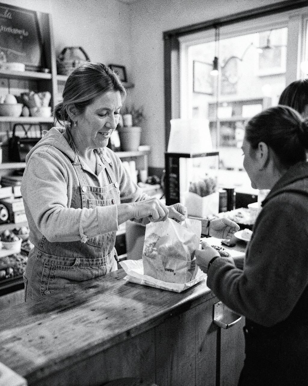 Local shop owner serving a customer